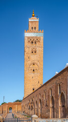 Obraz premium Kutubiyya Mosque is the largest mosque in Marrakesh, Morocco. Visitors can see its tall minaret and surrounding architecture during the day. Many people come to admire its design.