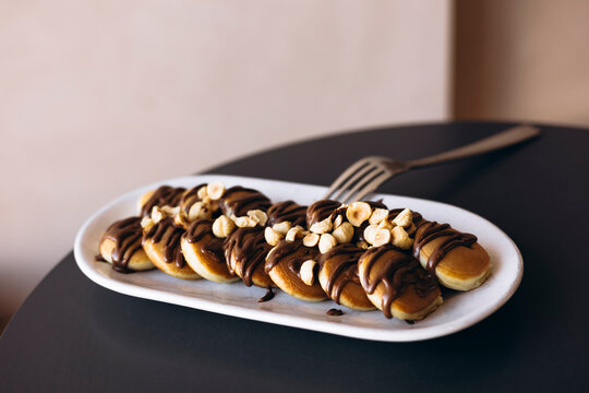 Mini pancakes with chocolate drizzle and hazelnut topping