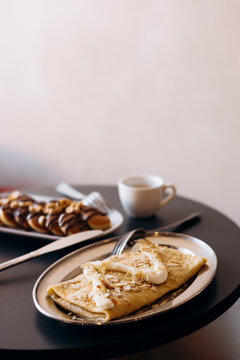 Breakfast pancakes and mini pancakes with coffee on table