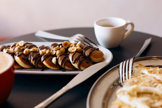 Breakfast with mini pancakes, chocolate, apple and coffee