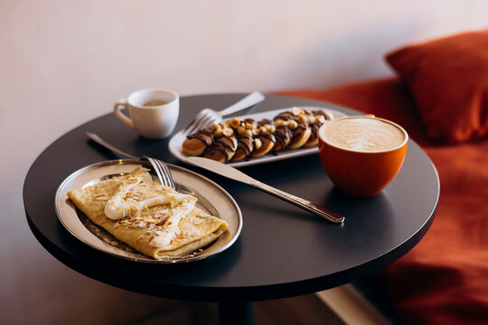 Breakfast table with mini pancakes, apple crepe and coffee