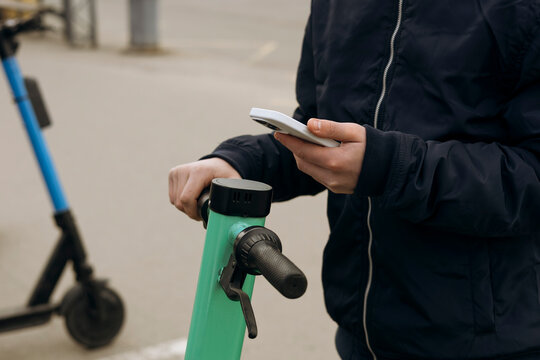 Person using smartphone to unlock an electric scooter