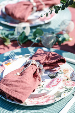 Spring table setting with floral plate and pink napkin