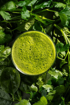 Spinach smoothie on fresh greens background, top view