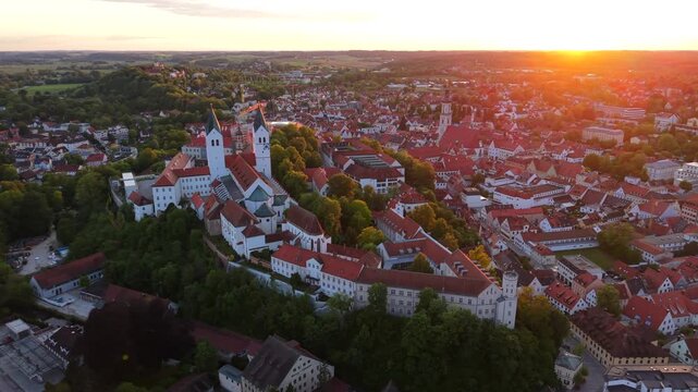 An aerial view of Freising, Germany, captures the cathedral hill, Dom St. Maria und St. Korbinian, St. George Church, and historic buildings forming a classic Bavarian old town panorama.
