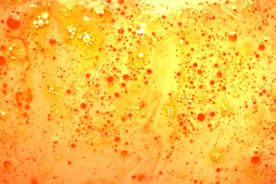 Abstract oil bubbles and spheres on bright yellow background