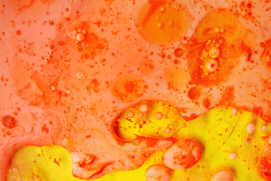Abstract oil bubbles and spheres on vibrant orange background