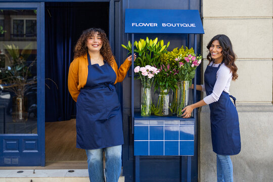 Flower shop exterior with smiling florists in blue aprons