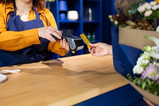 Florist processing payment in blue flower shop