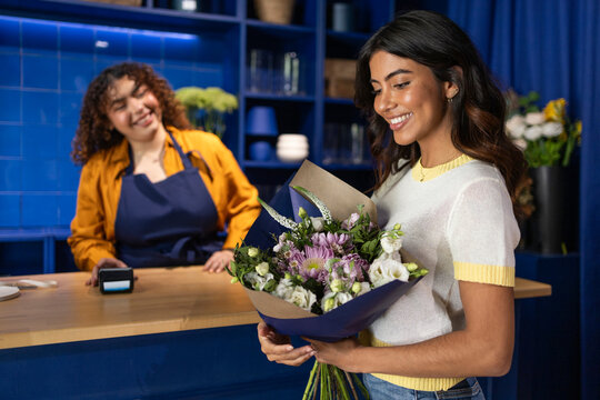 Florist assisting customer in blue-themed flower shop