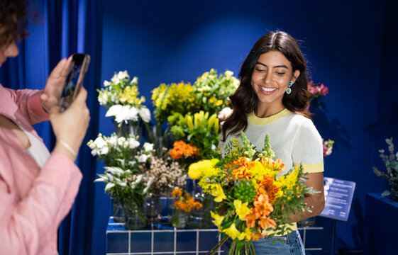 Customer admiring flowers in a vibrant blue flower shop