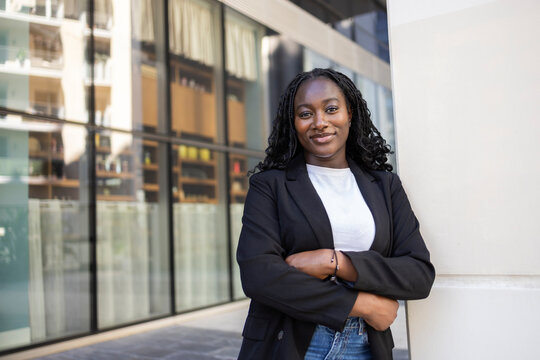 Confident African businesswoman standing by modern office