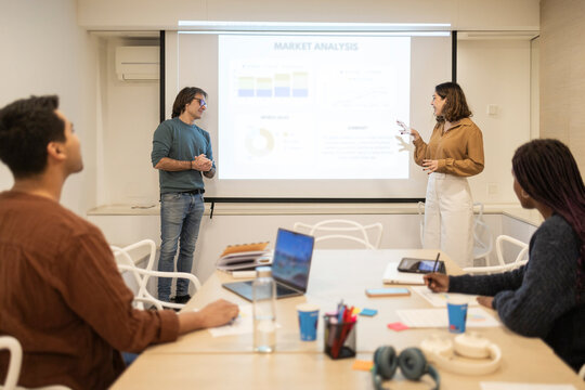 Coworking team presenting market analysis in modern office