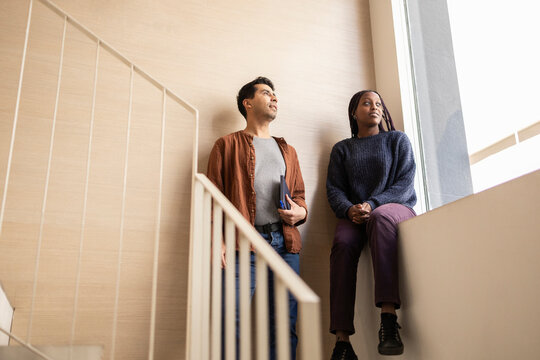 Coworking team taking a break by office staircase window