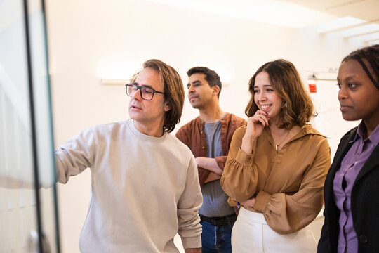 Diverse team meeting in coworking office planning on board