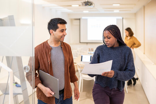 Collaborative coworkers reviewing documents in modern office