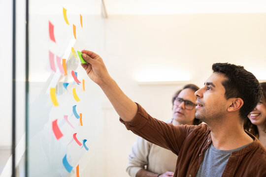 Team brainstorming with sticky notes in coworking office