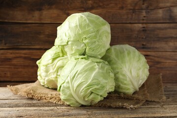 Fototapeta premium Fresh whole cabbages on wooden table, closeup