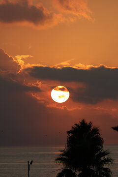 Dramatic sunset sky with sun and clouds