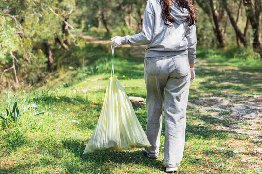 Volunteer collecting litter in park during community cleanup