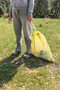 Volunteer holding trash bag during community park cleanup