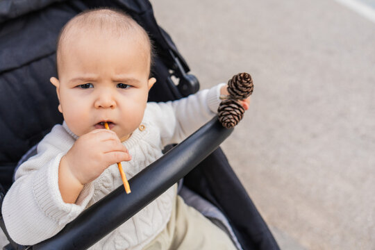 Baby in stroller enjoying snack at the park