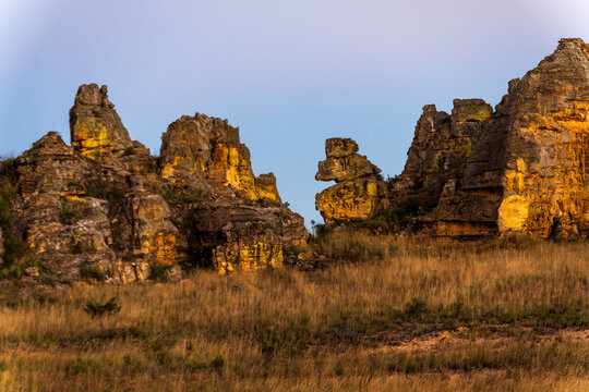 Sandstone rock formations rising from the savanna in Isalo National Park.