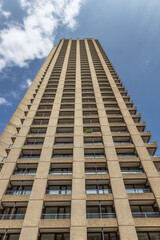 Fototapeta premium Tall concrete residential tower block reaching into a blue sky