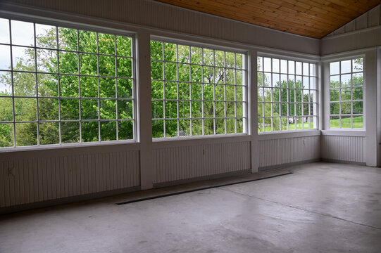 white painted window seals in a beautiful barn area with green trees