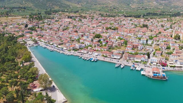 Picturesque aerial view revealing the beautiful coastal town of galaxidi in peloponnese, greece, showcasing the idyllic harbor with moored boats and traditional houses on a sunny summer day