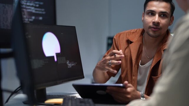 ortrait of a smiling young software developer discussing programming solutions and artificial intelligence parameters with a senior IT consultant.