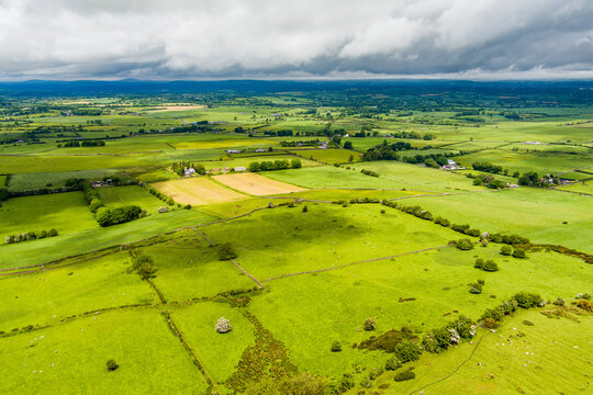Patchwork fields spread across County Meath, Ireland, under heavy cloud. A peaceful Boyne Valley farming landscape of hedgerows, pasture and rural roads.