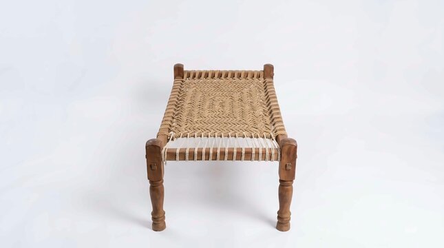 A traditional wooden charpai cot featuring intricate handwoven rope patterns captured in this clear studio photo.