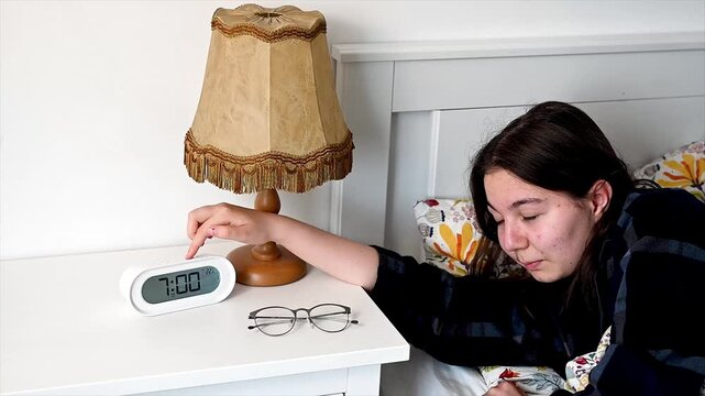 Sleepy teenager struggling to get out of bed on school morning with reluctant drowsy expression, relatable morning wake up moment showing authentic adolescent daily routine and genuine resistance to
