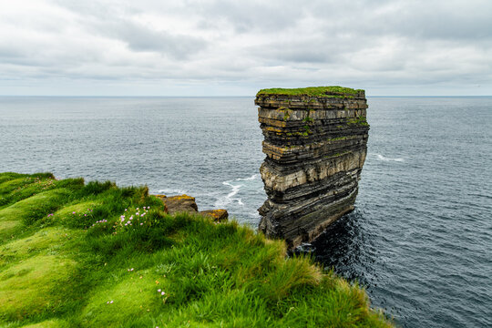 Dun Briste sea stack at Downpatrick Head, County Mayo, Ireland. Dramatic Atlantic cliffs, wildflowers and layered rock on the Wild Atlantic Way.