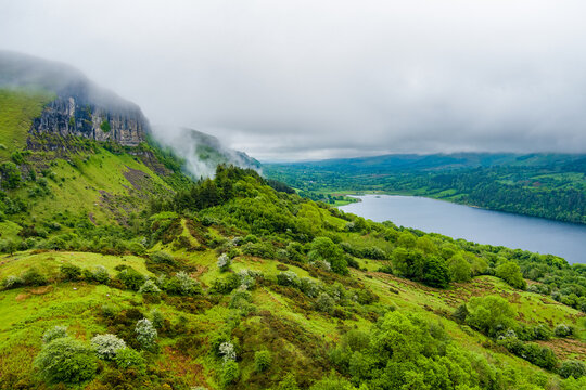 View from the Devils Chimney Waterfall area toward Glencar Lough in northwest Ireland. Misty green valley, lake and cliffs in the Sligo Leitrim border landscape.