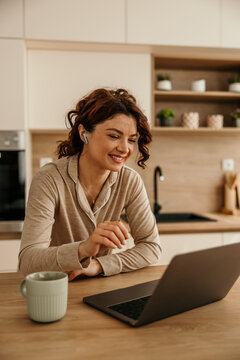 Woman in pajamas having video call on laptop at home