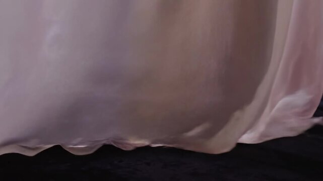 Gossamer fabric drapes with flowing texture cascading softly as delicate pleats create graceful shadows revealing ethereal translucence and subtle shimmer in this captured moment of textile