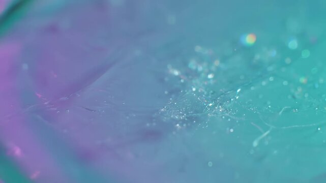 A vibrant, macro perspective of shimmering crystalline structures and iridescent reflections glows with an ethereal blend of magenta and cyan hues, showcasing a captivating abstract texture