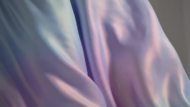 Flowing fabric drapes softly, displaying iridescent highlights and subtle color shifts that suggest a sense of ethereal beauty and luxurious textile texture, perfect for fashion or decor