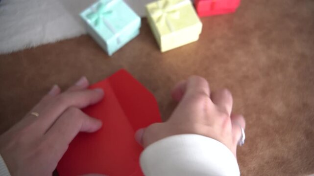 Video of a woman&rsquo;s hands placing a paper with &ldquo;I&rsquo;m Sorry&rdquo; into an envelope with gifts nearby. Apology and emotional communication concept.
