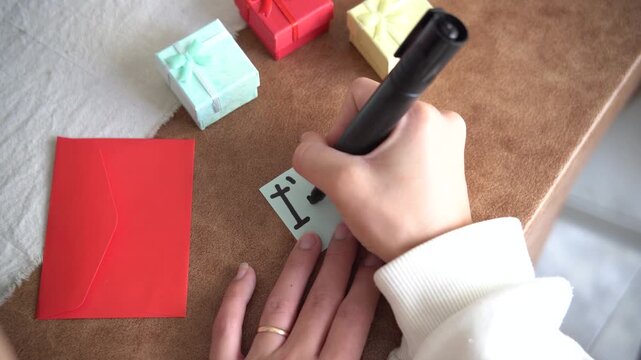 Video of a woman&rsquo;s hands writing &ldquo;I&rsquo;m Sorry&rdquo; on paper with gifts around. Apology, forgiveness, and emotional communication concept.
