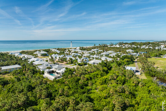 Expensive mansions between green palm trees on Gulf of Mexico shore in island small town Boca Grande on Gasparilla Island in southwest Florida, USA. Aerial view of wealthy waterfront neighborhood