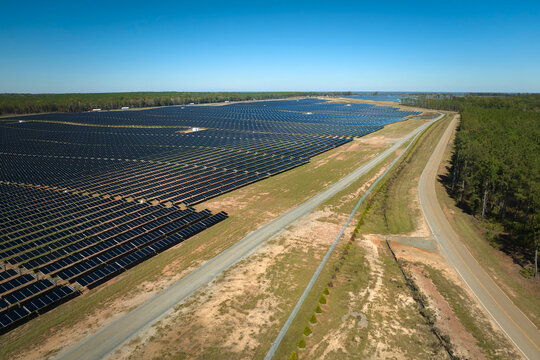 Aerial view of big sustainable electric power plant with many rows of solar photovoltaic panels for producing clean electrical energy. Renewable electricity with zero emission concept