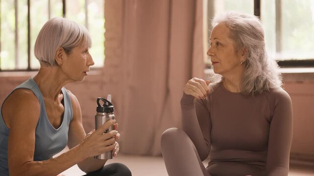 Senior woman in sportswear discussing recent workout with her female friend