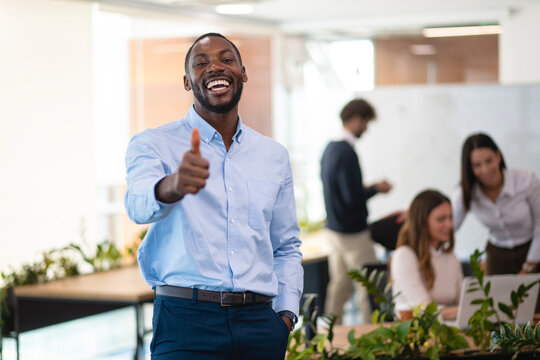 Happy black businessman giving thumbs up approving excellent work