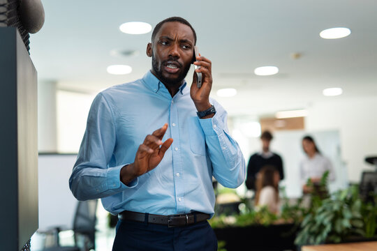 Stressed businessman having intense phone call in office