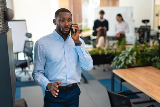 African american businessman having phone conversation in modern office