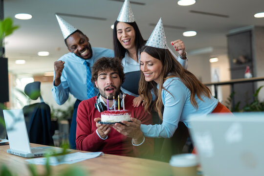 Coworkers surprising man with birthday cake in office