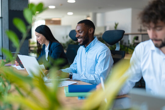 Diverse business professionals collaborating happily in modern coworking office